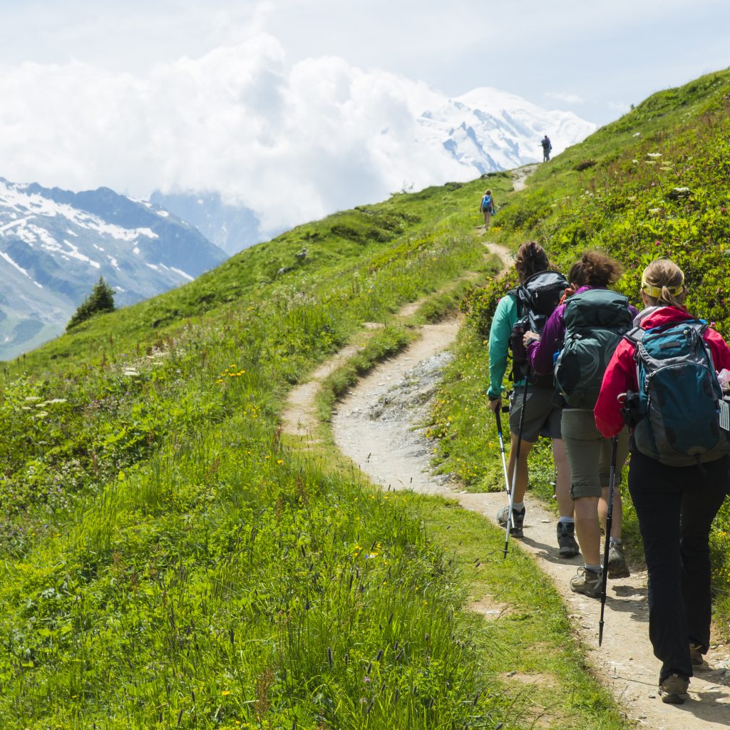 Gruppe von Wanderern auf einem Pfad in den Alpen bei einer Alpenüberquerung