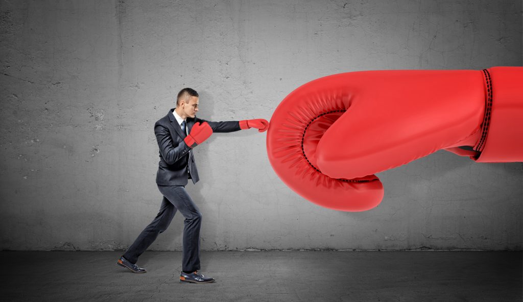 Symbolbild für Beat the Boss: Ein Mann boxt einen Boxhandschuh