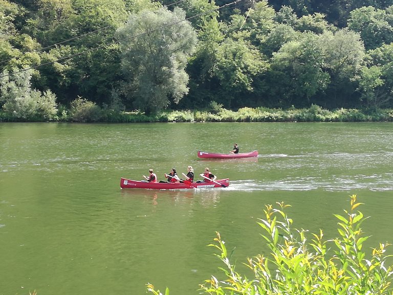 Menschen fahren in ihrem Kanu einen Fluß hinab