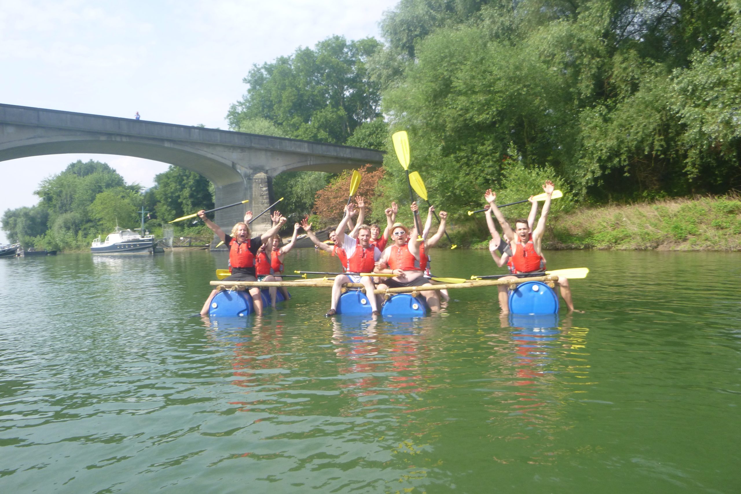 Teilnehmer beim Floßbau auf ihren flößen auf dem Wasser