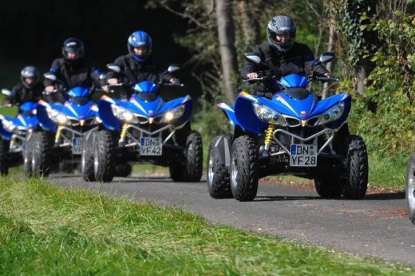 Fahrer mit ihrem Quad auf einem Asphaltweg im Wald