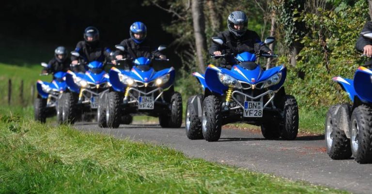 Fahrer mit ihrem Quad auf einem Asphaltweg im Wald