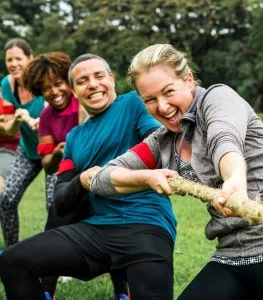 Menschen beim Tauziehen bei einem Teamevent