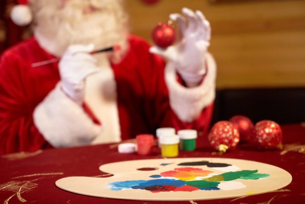 Weihnachtsmann beim bemalen einer Christbaumkugel beim Event Weihnachtliches Teampainting