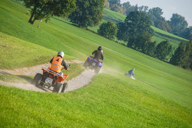 Fahrer mit ihrem Quad von hinten auf einem Feldweg