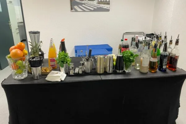 Tisch mit verschiedenen Getränken und Cocktailzubehör beim Cocktailkurs