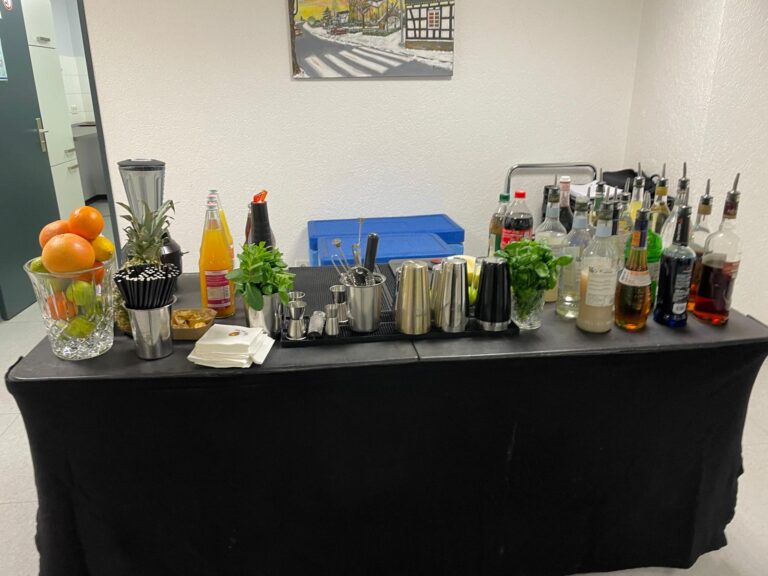 Tisch mit verschiedenen Getränken und Cocktailzubehör beim Cocktailkurs